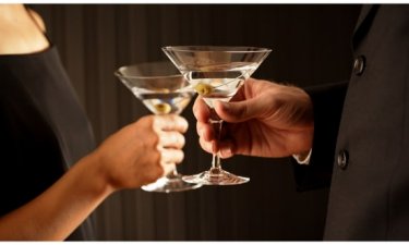 Woman and man holding a glass of martinis each